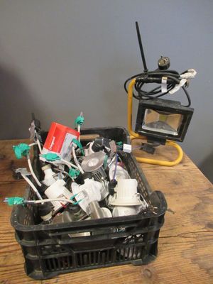 un bac noir rempli d'objets divers posé sur une table en bois