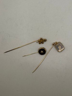 two pairs of gold earrings with black and white stones on them