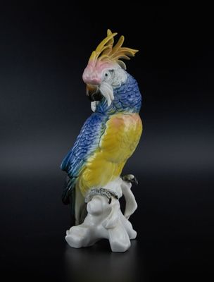 une figurine représentant un perroquet perché sur une branche d'arbre