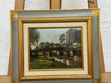 painting of a bridge over a river on a wooden easel