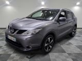une Nissan QX-V grise garée sur un sol à damier