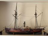 une maquette de bateau posée sur une étagère dans une pièce