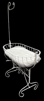a white baby crib with a white blanket on it