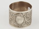 an antique silver napkin ring with a floral design on it