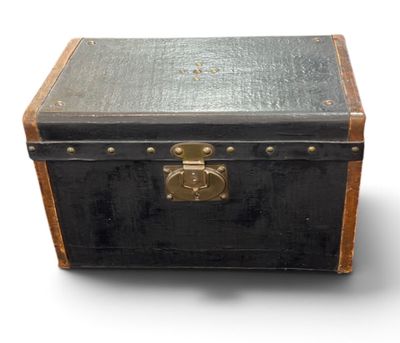 une vieille valise noire munie d'une serrure en laiton