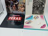 trois vinyles de Texas Records, dont l'un comporte la photo du visage d'une femme, et un
