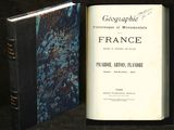 un livre ouvert posé sur une table à côté d'un livre
