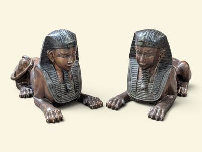 deux statues de pharaons allongés sur une surface beige