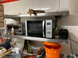 un micro-ondes posé sur une étagère dans une cuisine