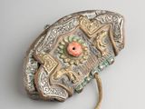 a silver and gold brooch with a flower on it