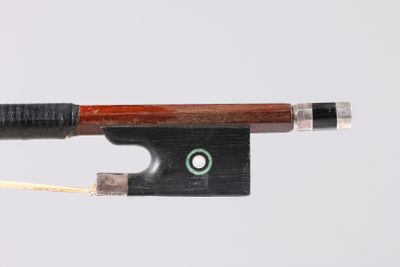 un archet de violon avec un point vert à son extrémité