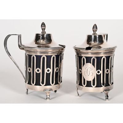 two silverplated sugar and pepper shakers with black and white designs