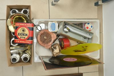 une boîte contenant divers objets, posée sur un sol carrelé