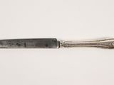 a close up of a knife on a white surface with a white background