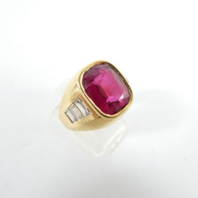 un gros plan d'une bague en or sertie d'un rubis et de diamants taille baguette
