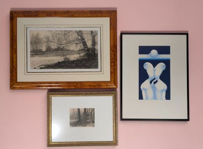 trois tableaux encadrés accrochés au mur au-dessus d'un lit
