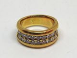 bague en or jaune sertie de diamants blancs sur un fond blanc