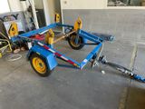 a blue trailer with two yellow wheels in a garage