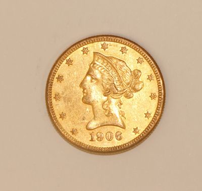 a close up of a gold coin with a woman ' s head on it