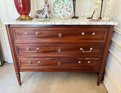 a dresser with a marble top in a room