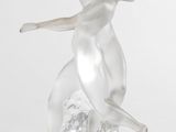 une image représentant une sculpture en verre représentant une femme assise sur un rocher