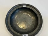 a black metal bowl sitting on top of a white table