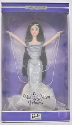 poupée dans la boîte d'une poupée Barbie, vêtue d'une robe et portant des perles