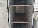 a white refrigerator with shelves inside of it on the floor