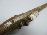 an old wooden gun with a metal handle on a white surface