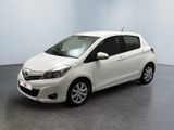La Toyota Yaris est garée dans une pièce blanche au sol gris.