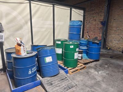 many barrels sitting on a pallet in a warehouse