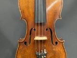 un violon ancien, accompagné de son étui en bois et de son archet, exposé