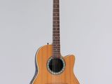 an acoustic guitar hanging on a wall with a white background