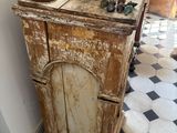 an old wooden cabinet with a vase on top of it