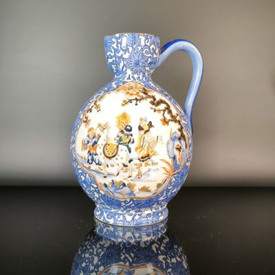 a blue and white vase sitting on a black table