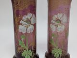 pair of vases with floral designs on them sitting on a table