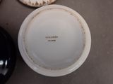 a white plate with a black bowl sitting on a table