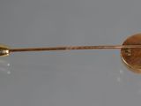 a close up of a gold pin on a table