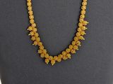 un collier composé de perles jaunes, présenté sur un mannequin