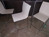 deux chaises blanches et une table dans une pièce