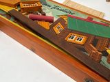 a wooden box with a game on it and a pencil in it
