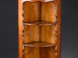 une armoire d'angle ancienne en bois, dotée de trois étagères