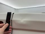 a hand that is holding a measuring tape in front of a microwave