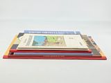 three books stacked on top of each other on a white surface