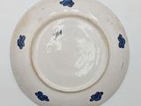 a white plate with blue flowers on it on a white surface