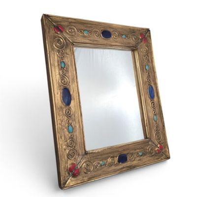 an image of a gold framed mirror with blue and red stones