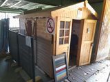 a wooden shed with a no parking sign on the door