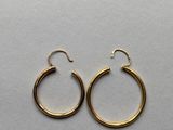a pair of gold hoop earrings on a white background