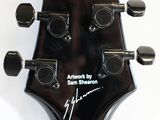 the head of a guitar with a signed signature on the neck
