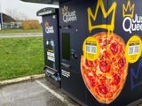 une boîte à pizza ornée d'une couronne, posée sur un parking
